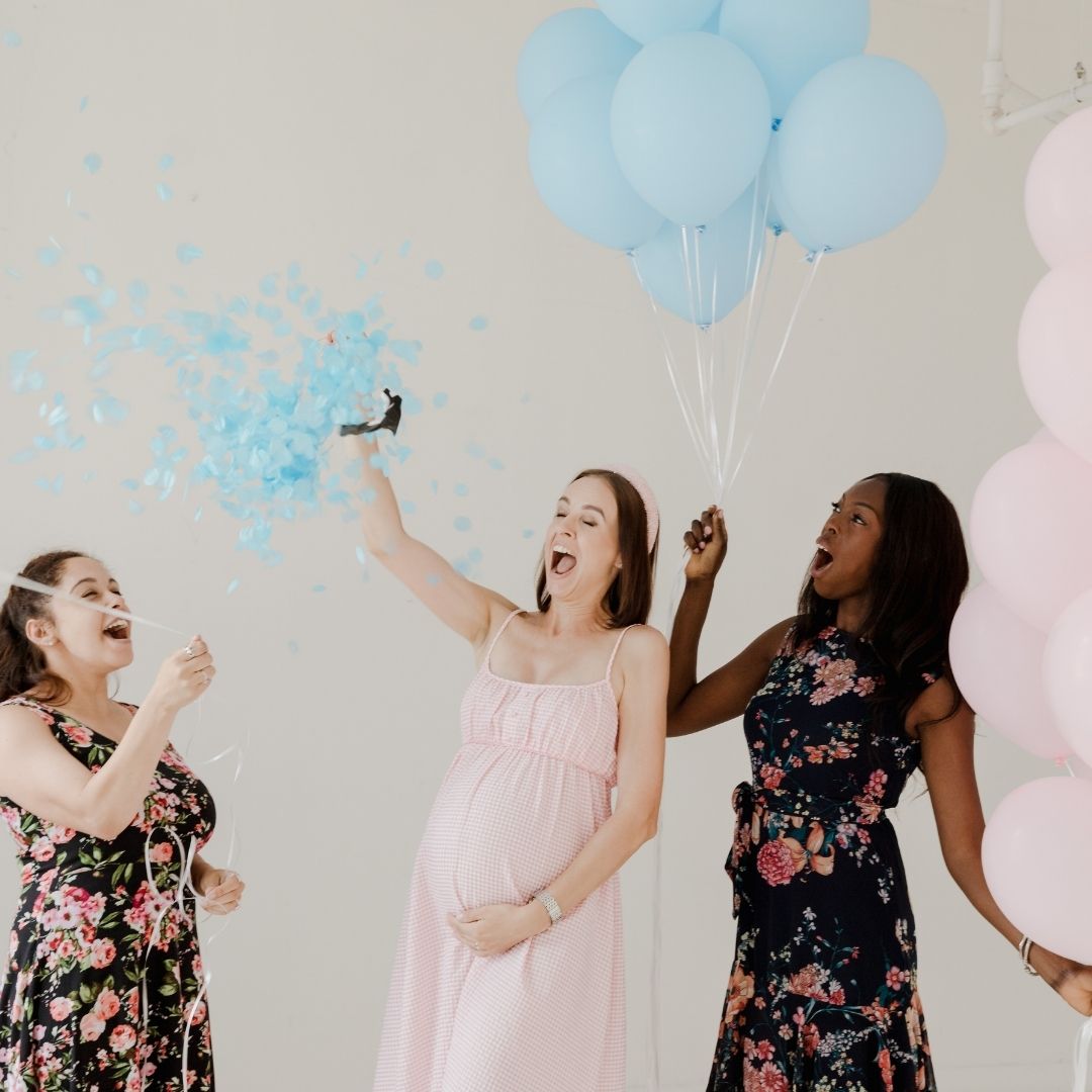 Ladies celebrating a gender reveal with balloons.